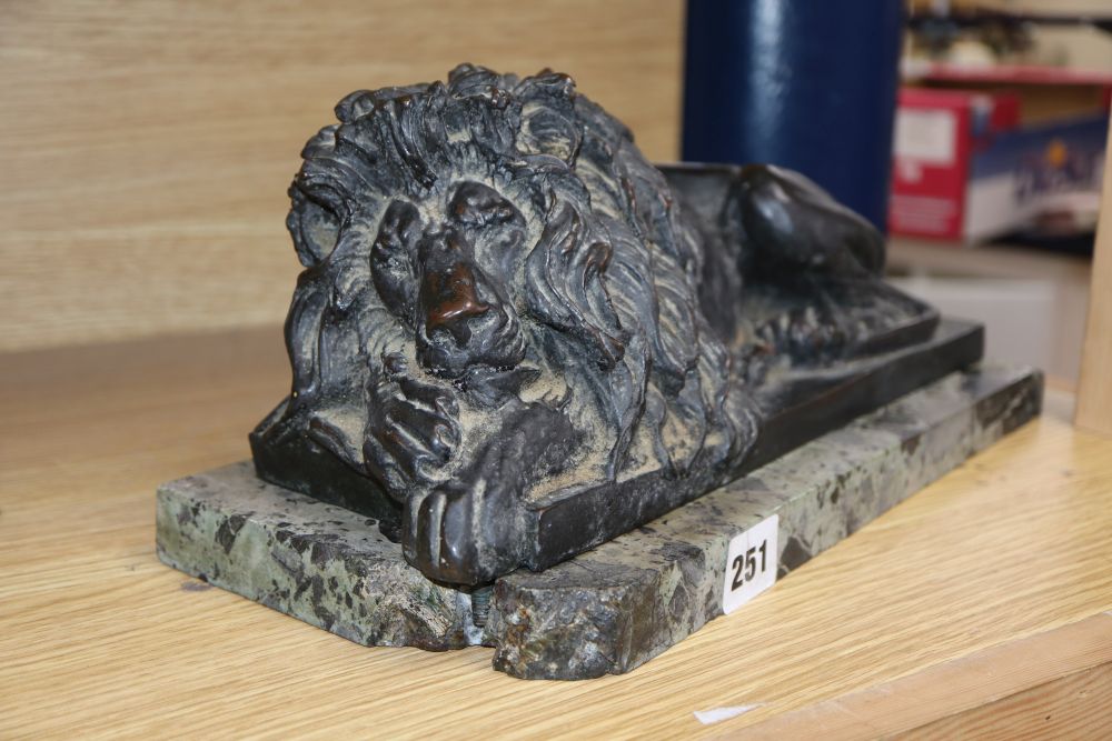 After Canova, a bronze recumbent lion, on a marble plinth, length 35.5cm